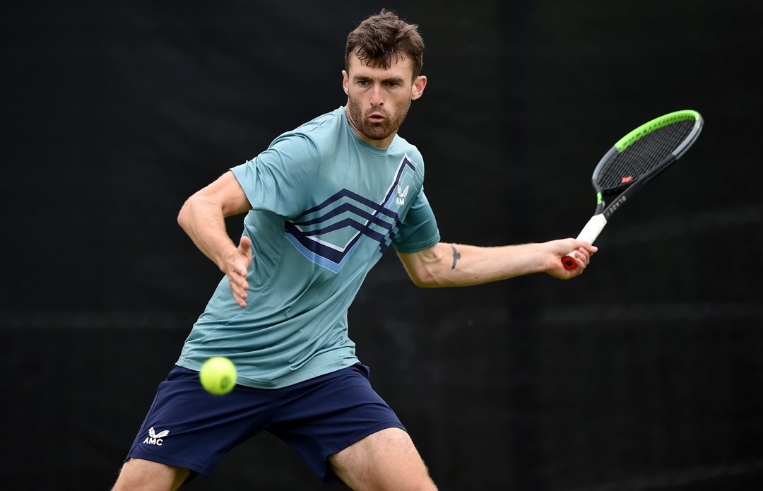 Giles Hussey swinging a tennis racket