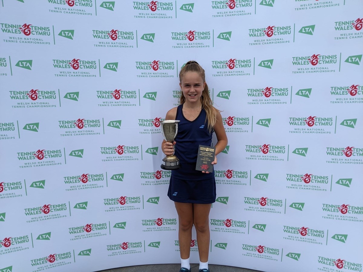 Madeleine posing with her trophy infront of the lta wales backdrop