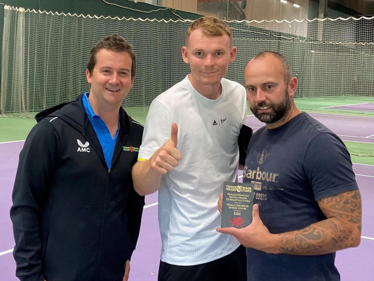 Three men posing with their awards at Tennis LTA indoor court