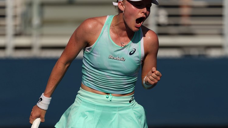 Female tennis player holding racket and celebrating