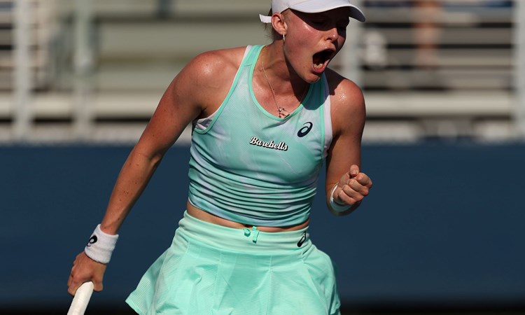 Female tennis player holding racket and celebrating