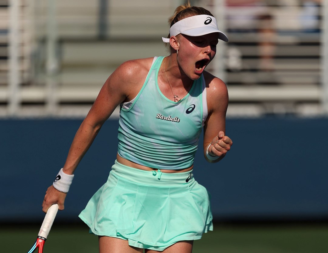 Female tennis player holding racket and celebrating