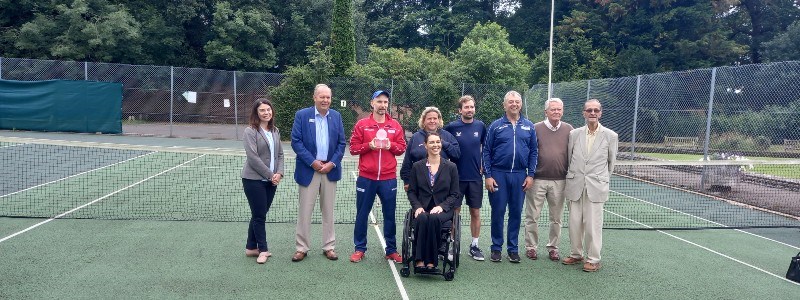 Group of players and coaches posing for a picture on the court