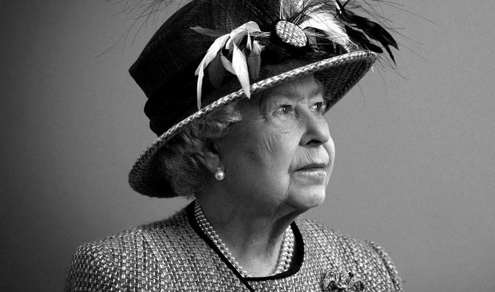 Her majesty the queen looking up at the  top right of a box