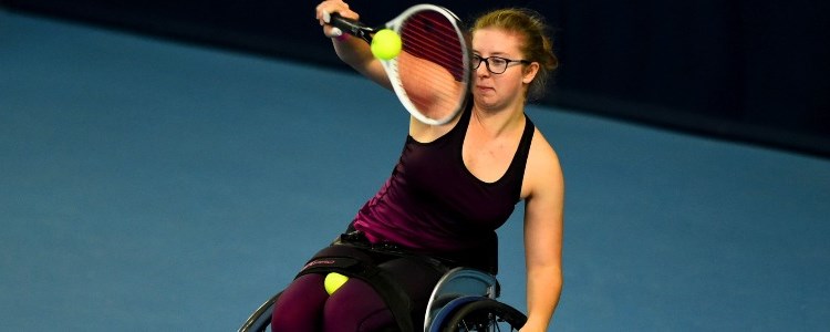 Wheelchair tennis player returning a serve with her mattress 