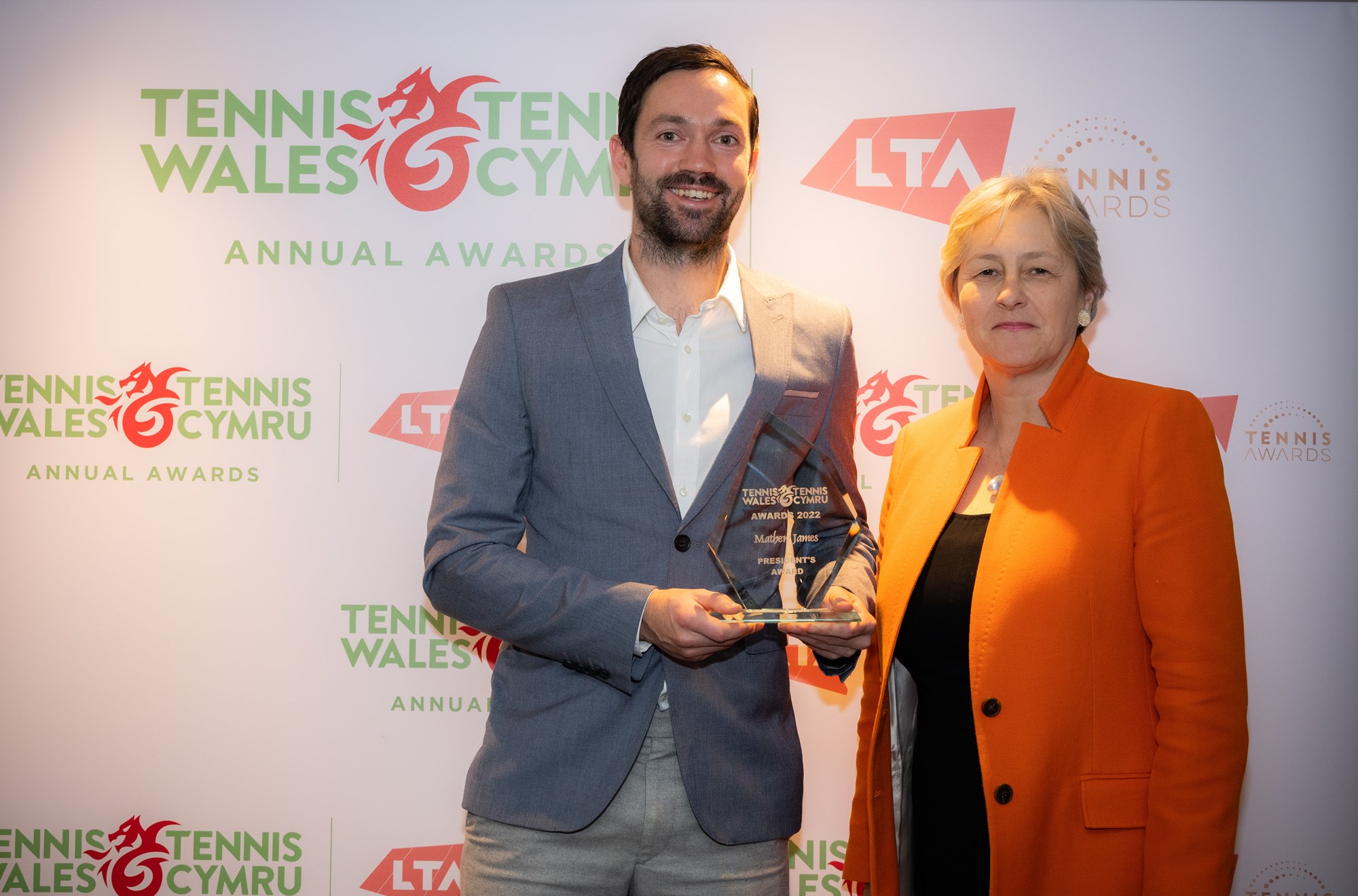 Award being handed over to a male tennis player at tennis wales
