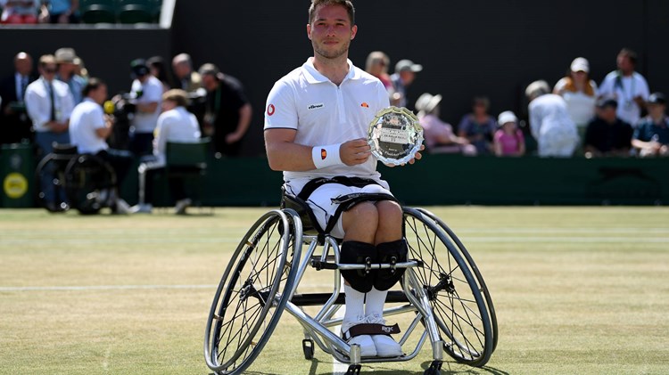 Male tennis player on wheelchair with a trophy