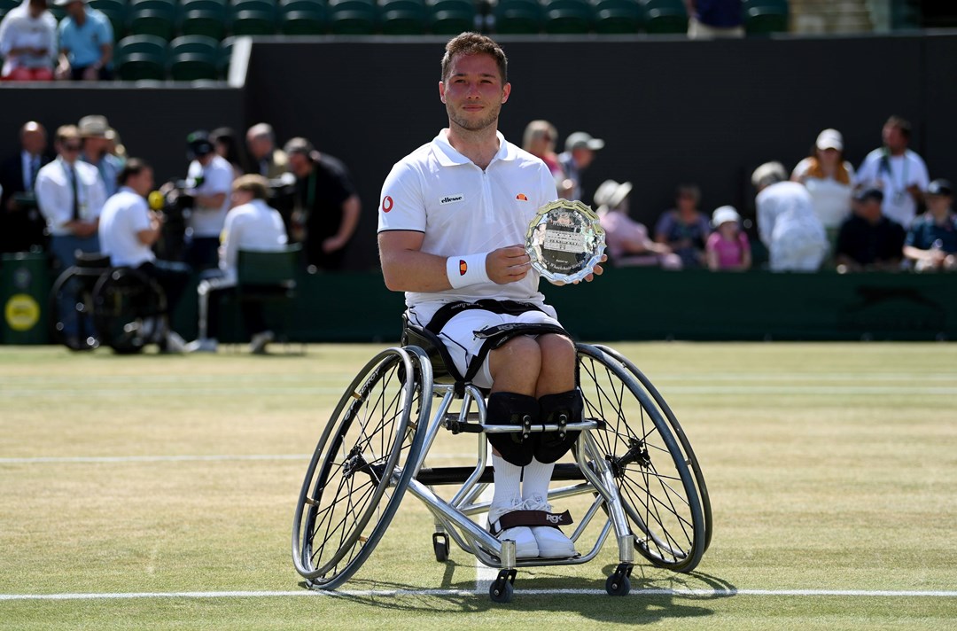 Male tennis player on wheelchair with a trophy