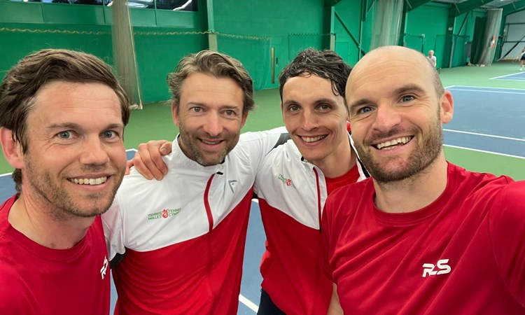 4 men posing infront of the camera in an indoor court