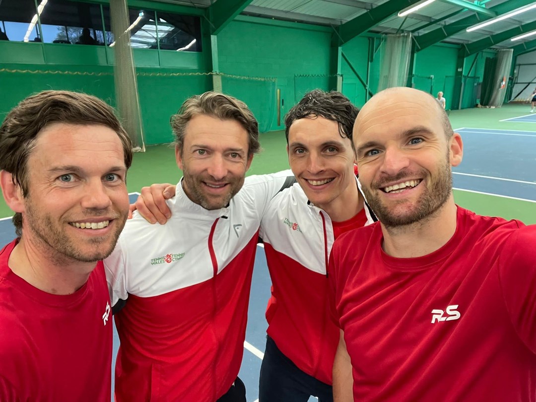 4 men posing infront of the camera in an indoor court