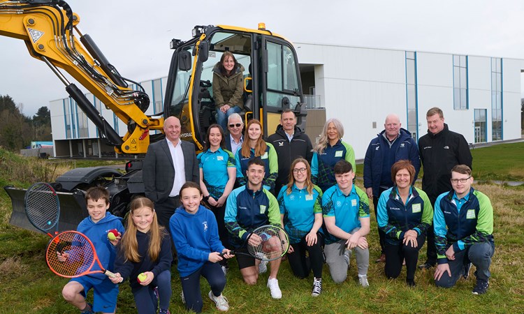 A group of people in front a construction machine
