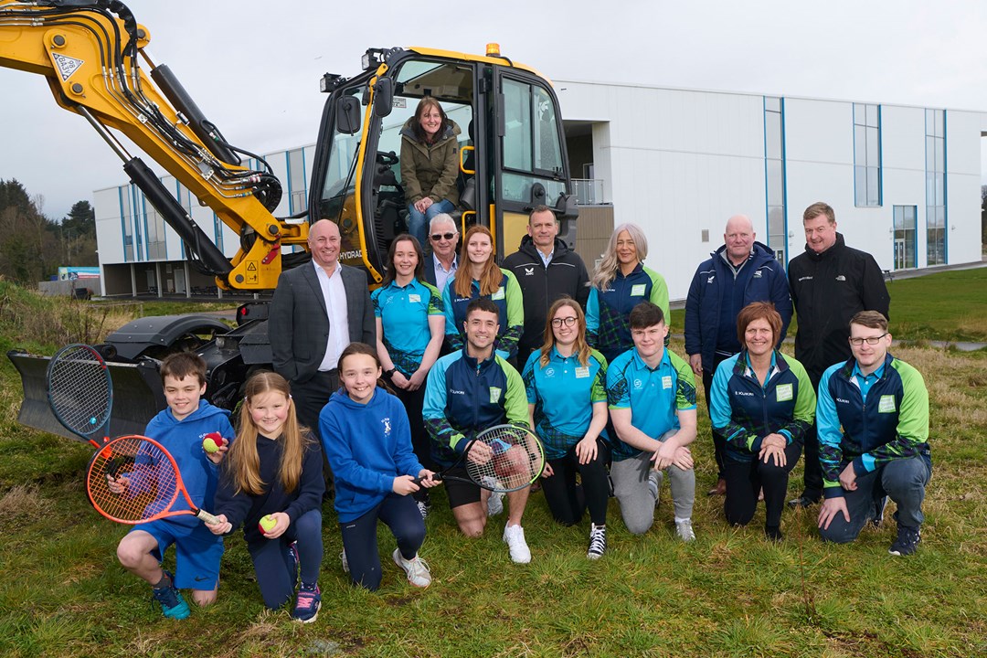 A group of people in front a construction machine