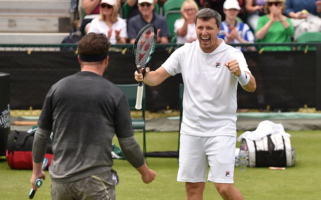 Two male tennis players cheering each other