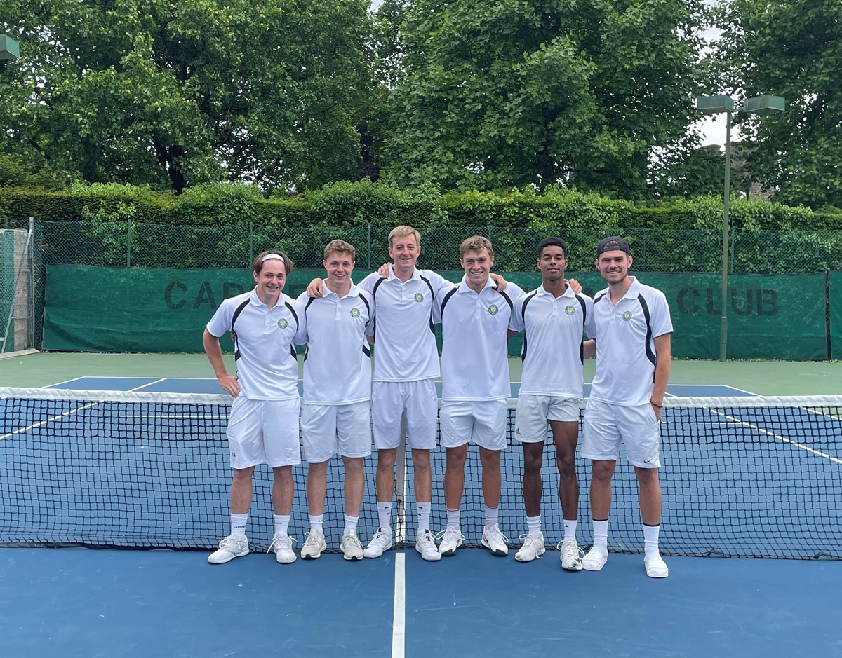 Male tennis players posing for a picture during a tennis lesson