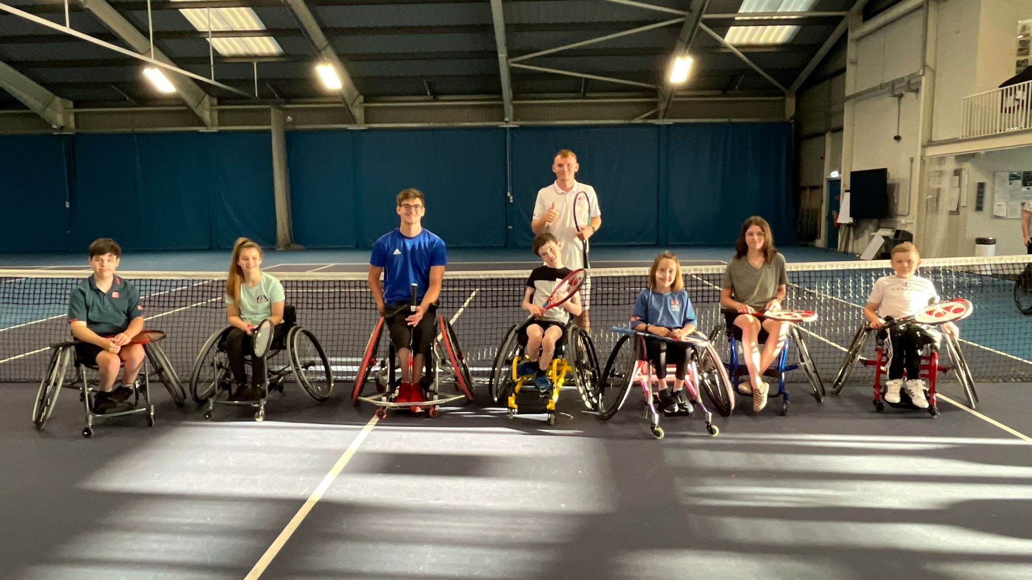 tennis wheelchair players posing for a camera after practice