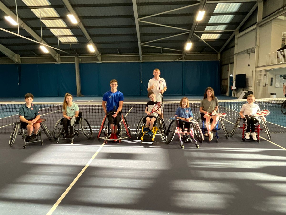 tennis wheelchair players posing for a camera after practice