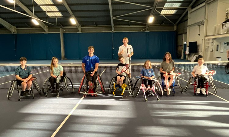 tennis wheelchair players posing for a camera after practice
