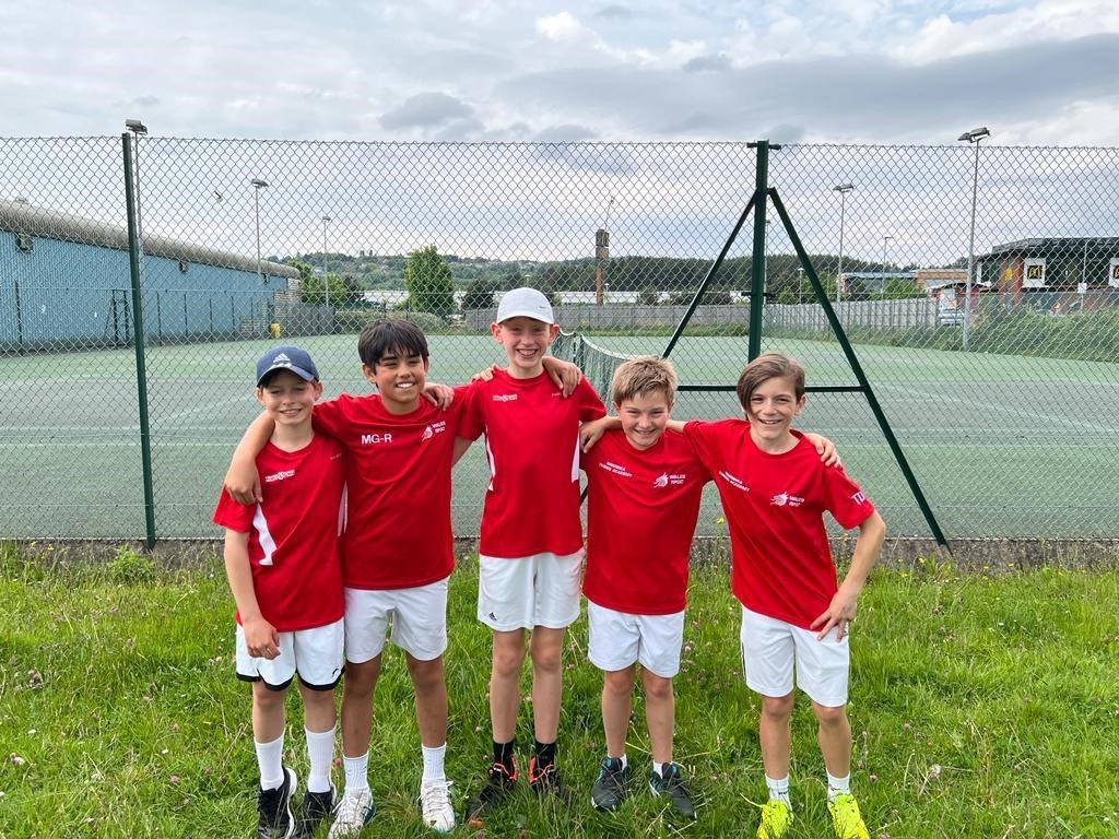 Young children posing after a youth tennis lesson on an outside court