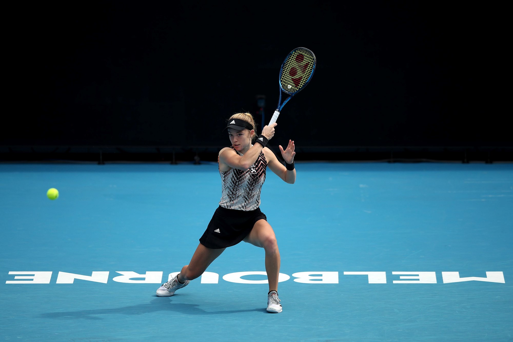 Female holding a tennis racket over her head
