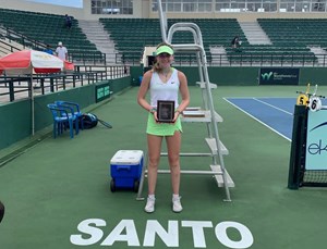 Ella standing infront of a commentator podium with her trophy