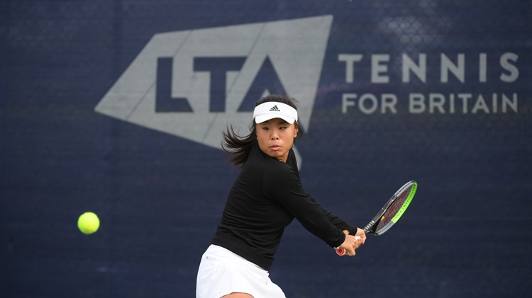 Female tennis player returning a shot mid game