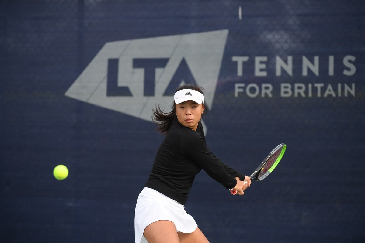 Female tennis player returning a shot mid game