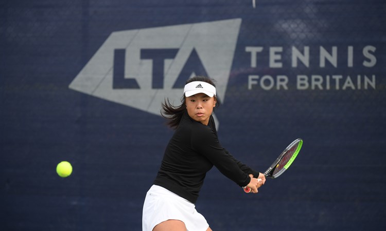 Female tennis player returning a shot mid game