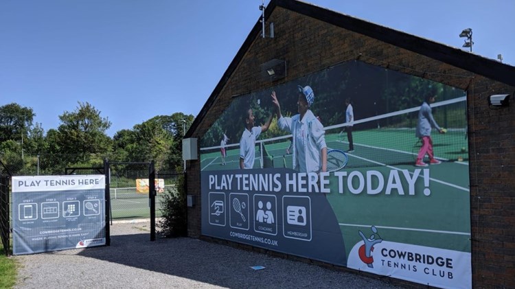 Play tennis here today sign on the wall of a venue 