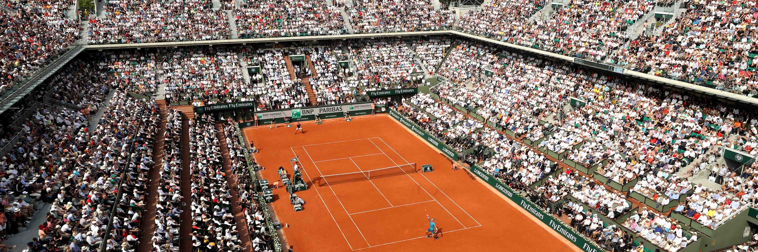 Clay court match with a stadium full of audience