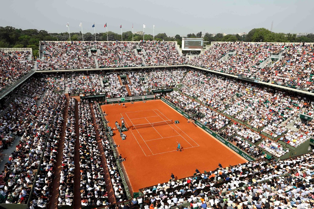 Clay court match with a stadium full of audience