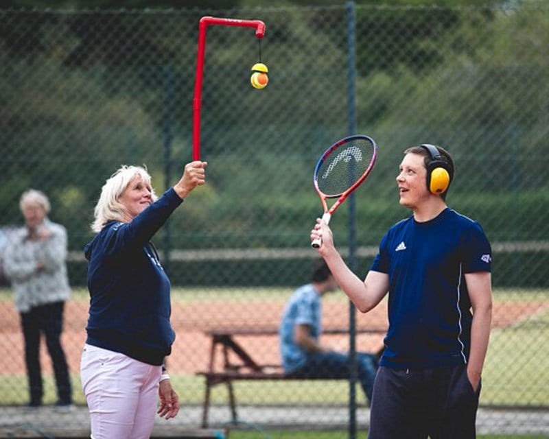 Male player holding racket and a women holding a ball 