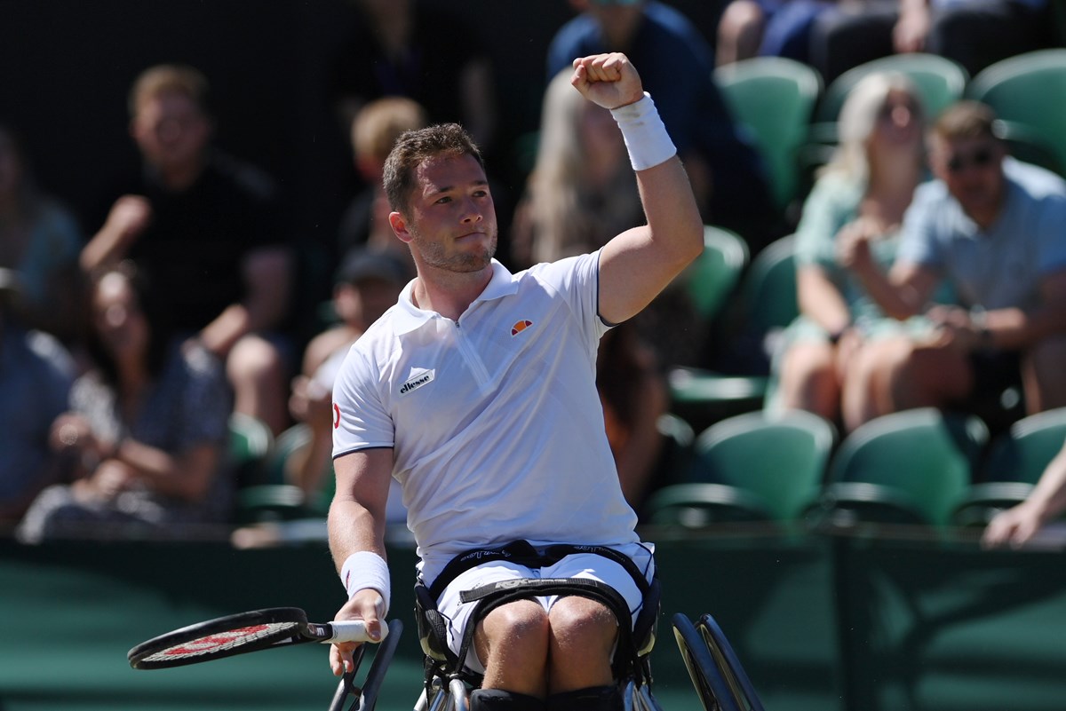Wheelchair tennis player cheering after a game win