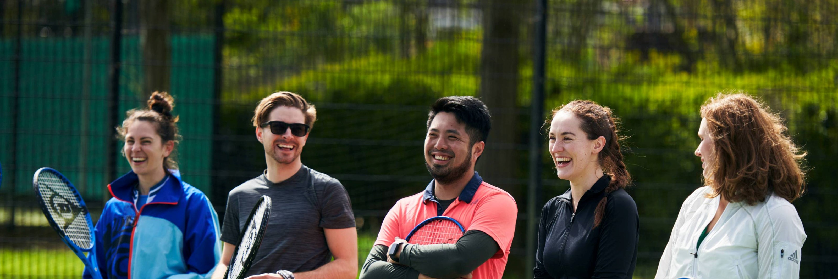 Free Park Tennis players laughing on court together