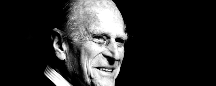 A black and white headshot of Prince Philip smiling