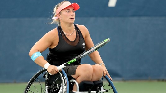 Lucy Shuker on court holding her tennis racket