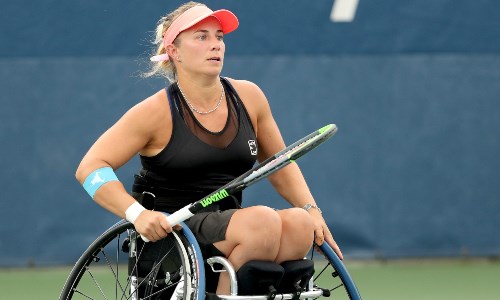 Lucy Shuker on court holding her tennis racket