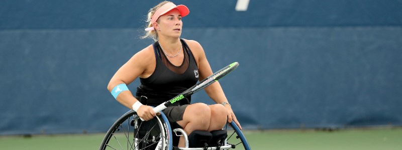 Lucy Shuker on court holding her tennis racket