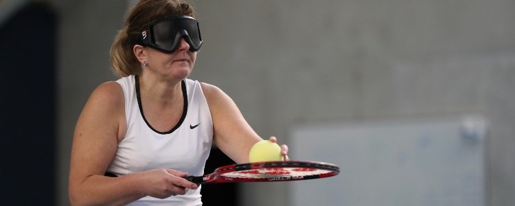 virtually impaired woman holding ball on racket