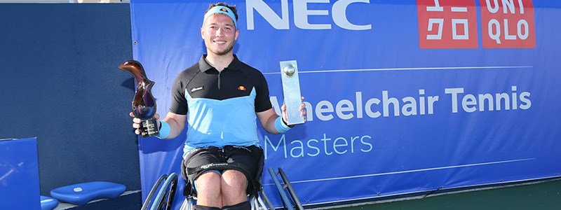 Alfie Hewett smiling in his wheelchair and holding his two awards in both hands