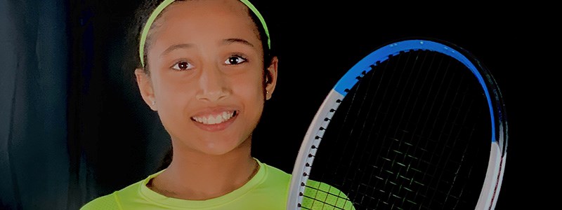 10-year-old Iraja Nagim holding a tennis racket