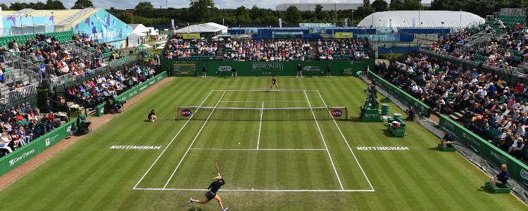An action shot of two players on court with spectators in the stands