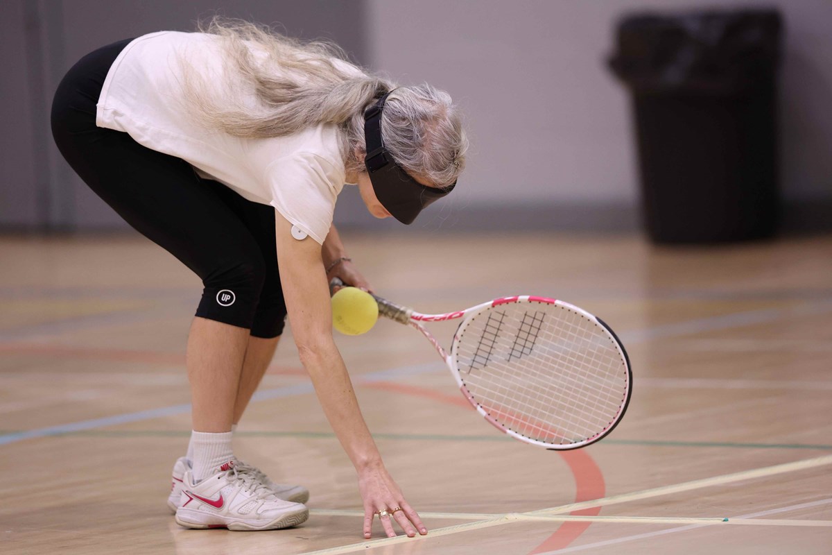 A woman playing visually impaired tennis