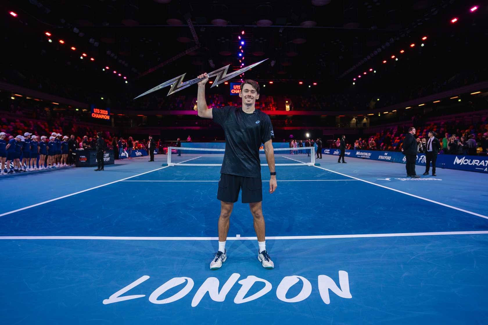 Alex de Minaur holding the 2025 Ultimate Tennis Showdown trophy
