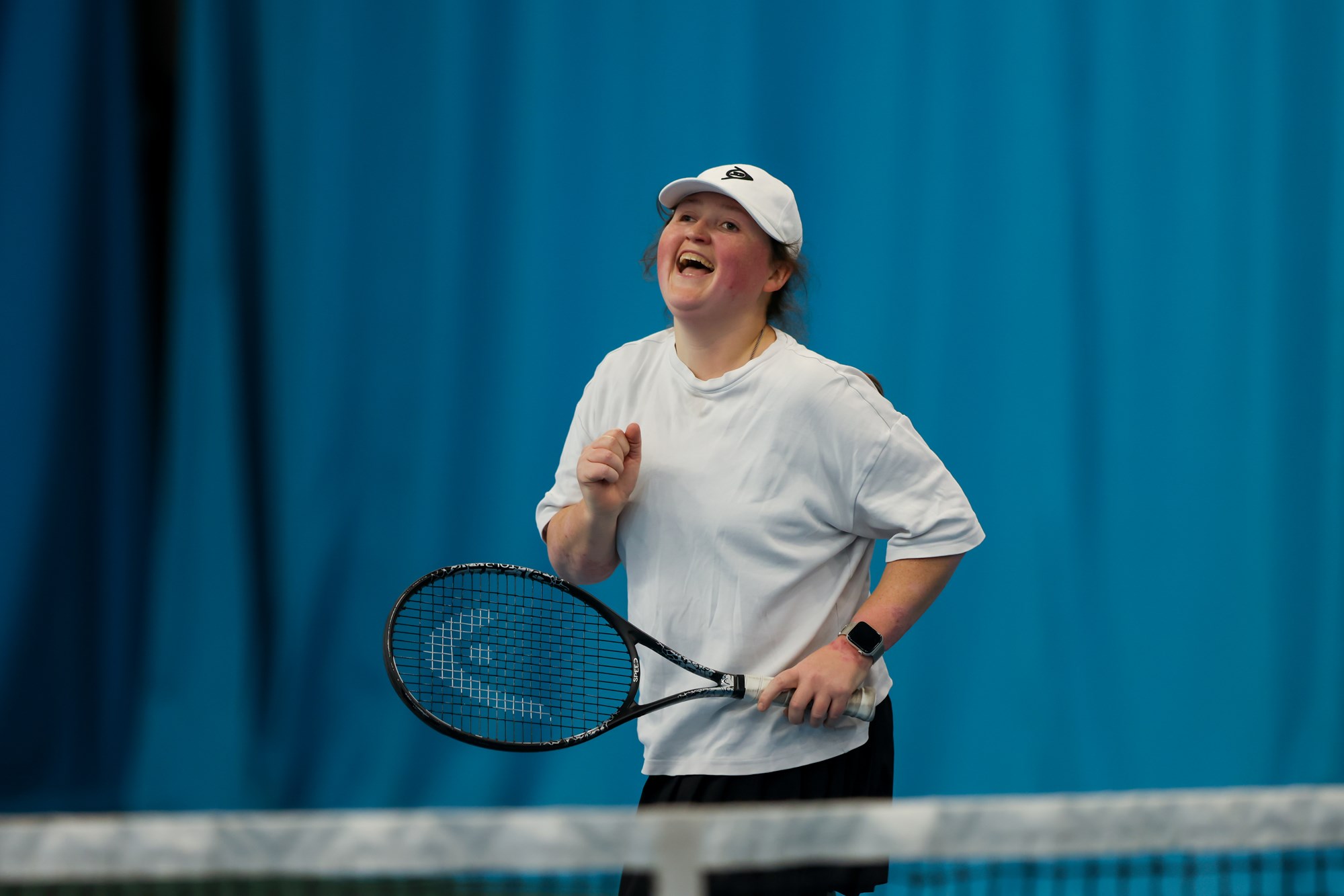 A player laughing on court during the Visually Impaired Tennis National Championships