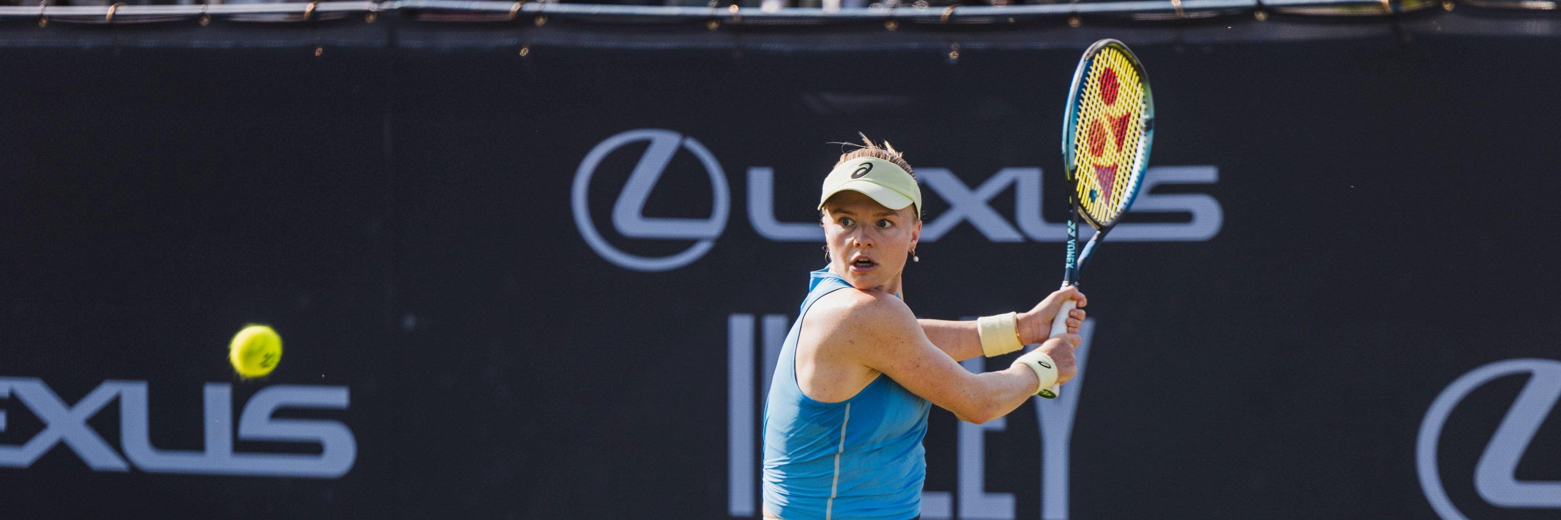 British tennis player Harriet Dart preparing to hit a backhand on court at the Lexus Ilkley Open as a tennis ball comes towards her
