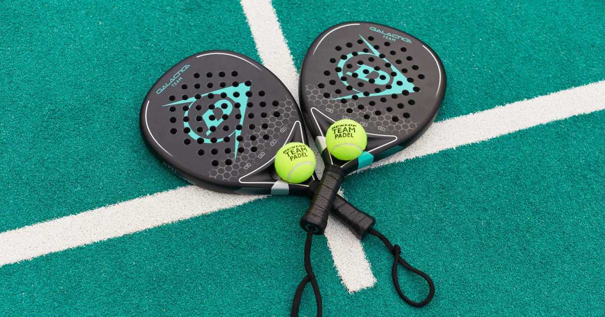 Two Dunlop padel rackets and balls on a court, illustrating the equipment used in padel