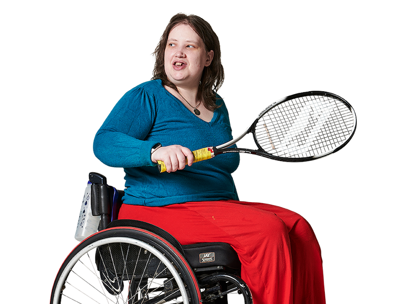 Woman in a wheelchair, with a tennis racket in her hand, looking over her shoulder