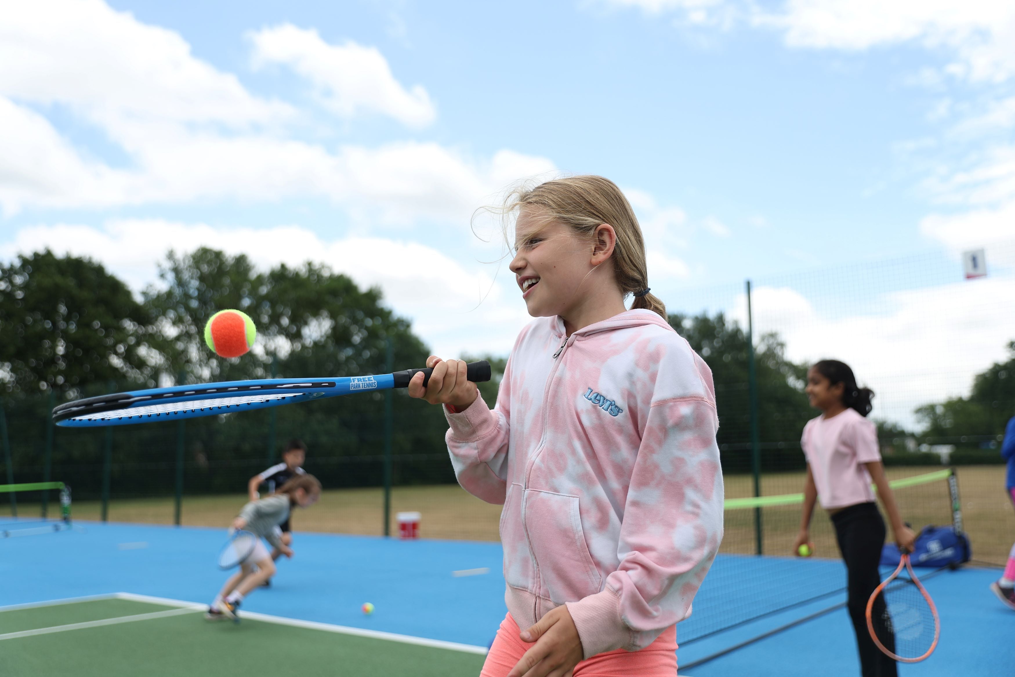 Girl holding racket and ball.jpg