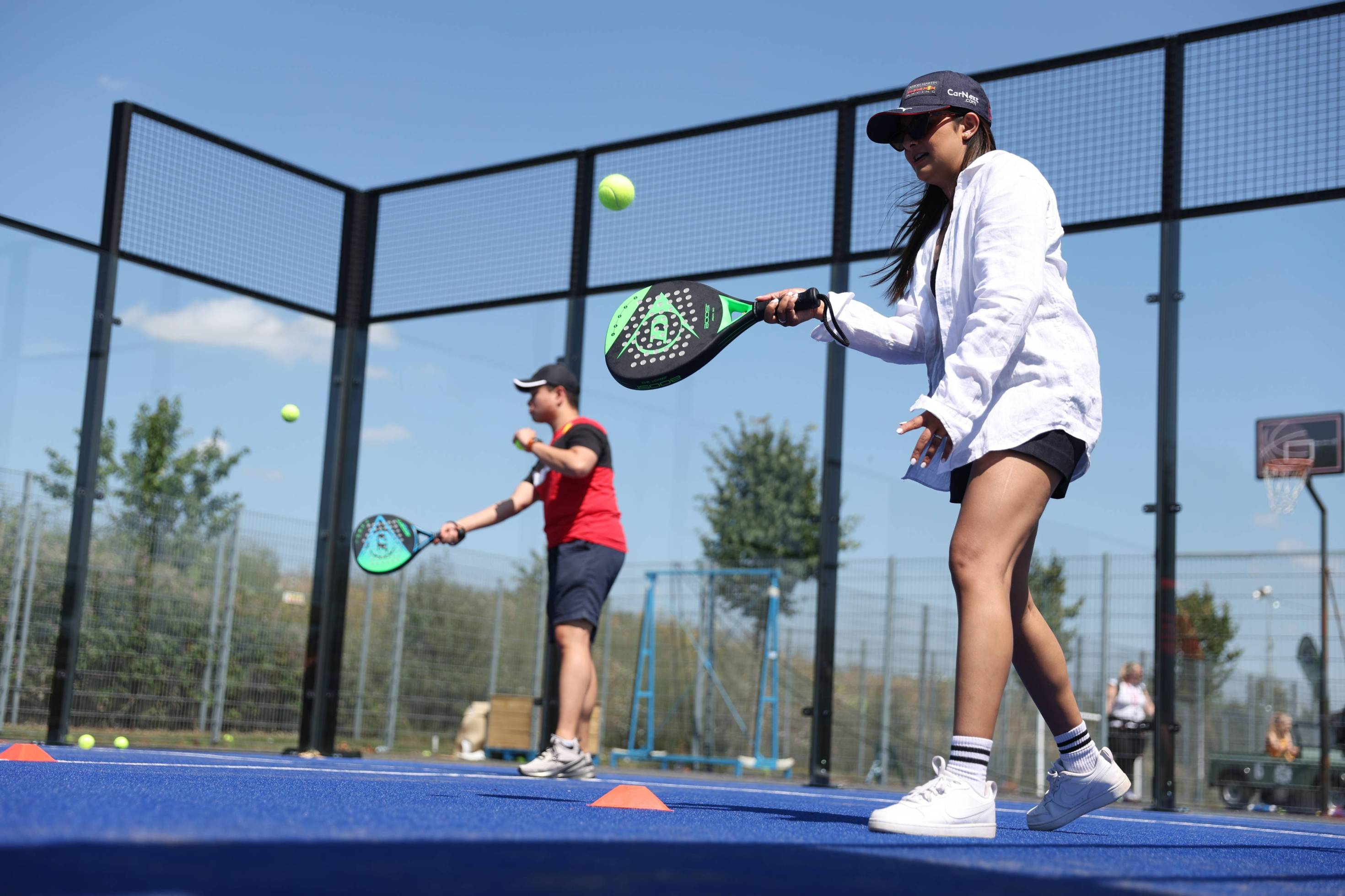 Two padel players practising on an outdoor court