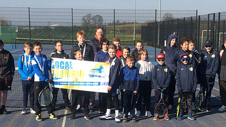 group of youth and coach standing on court at Cheslyn Hay tennis club holding a Team Challenge sign